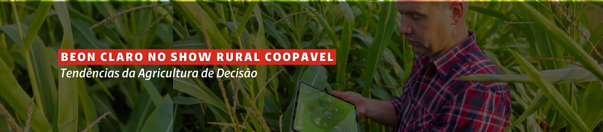 Na imagem vemos um campo de plantação com muitas folhas verdes, e um homem branco com um tablet na mão verificando informações de agro